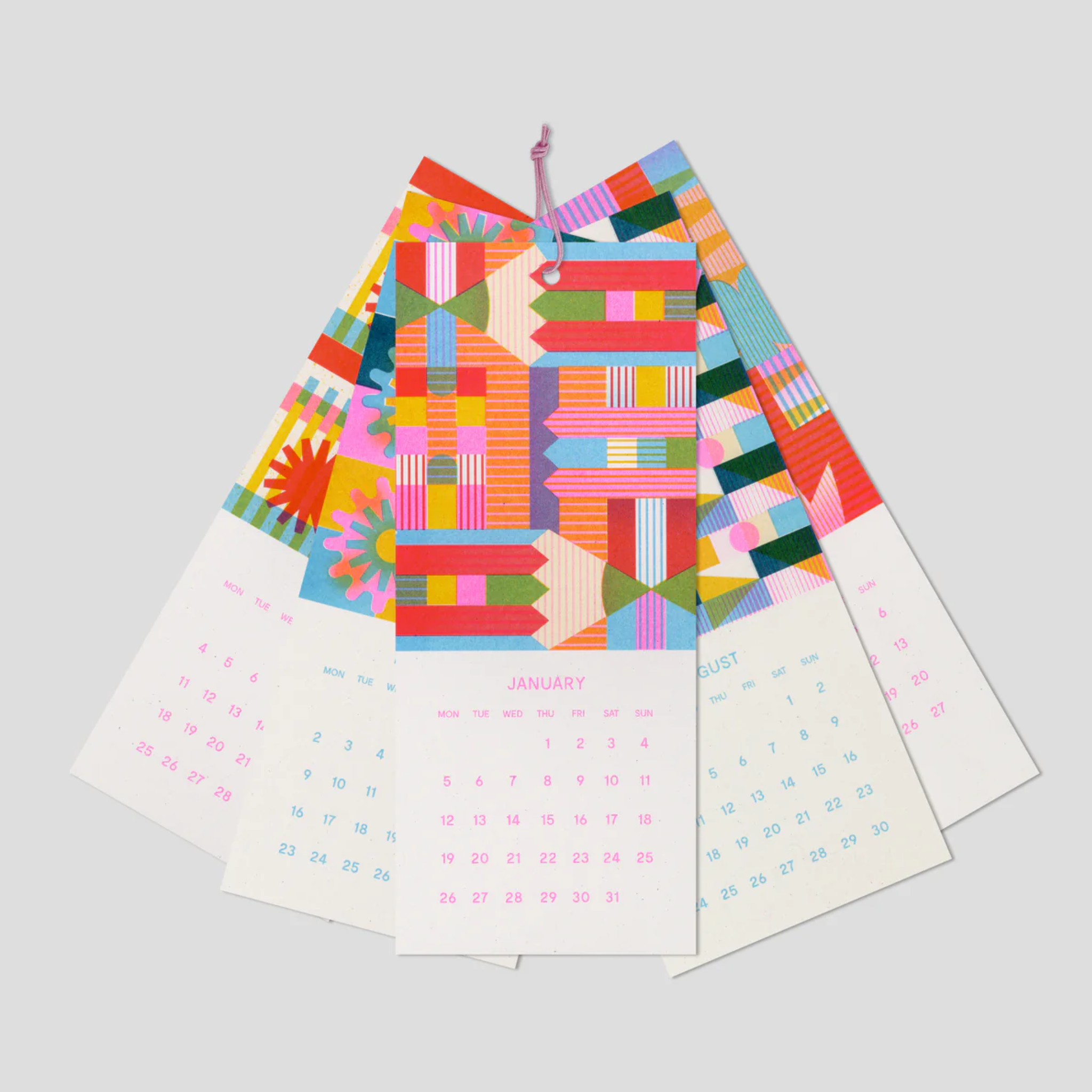 Colorful geometric-patterned calendar sheets on a light gray background