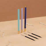A set of three color-coded pens with gold accents and matching refills, presented on a neutral background.