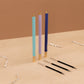 A set of three color-coded pens with gold accents and matching refills, presented on a neutral background.