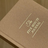 Brown journal with 'The Five Minute Journal' embossed on it