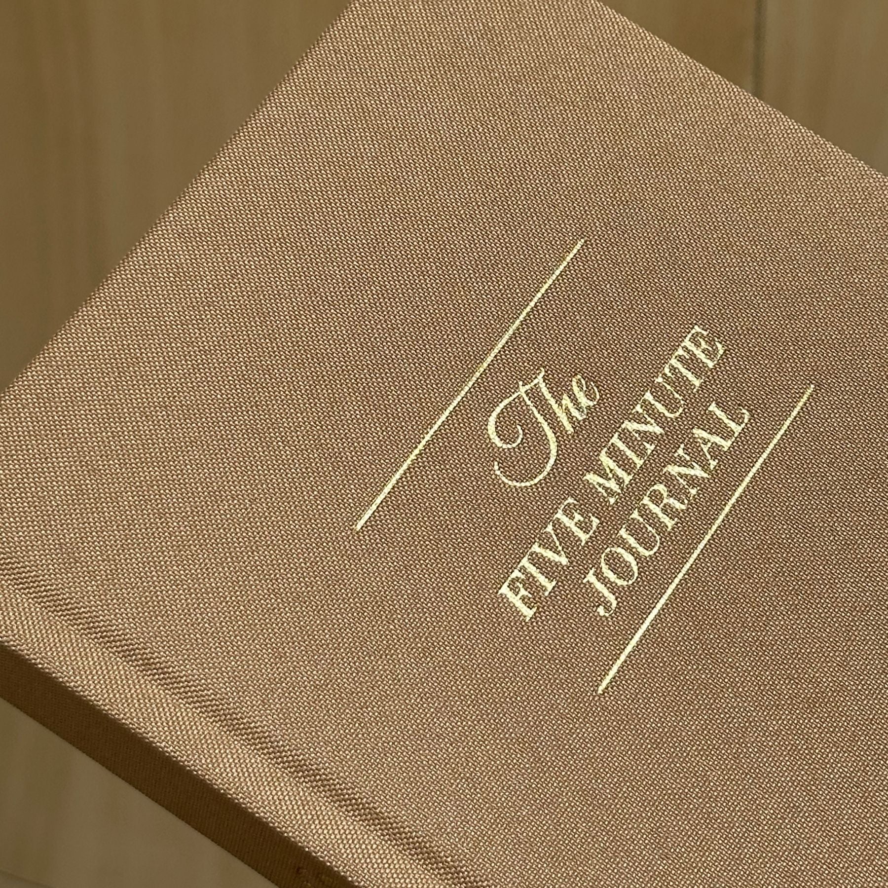 Brown journal with 'The Five Minute Journal' embossed on it