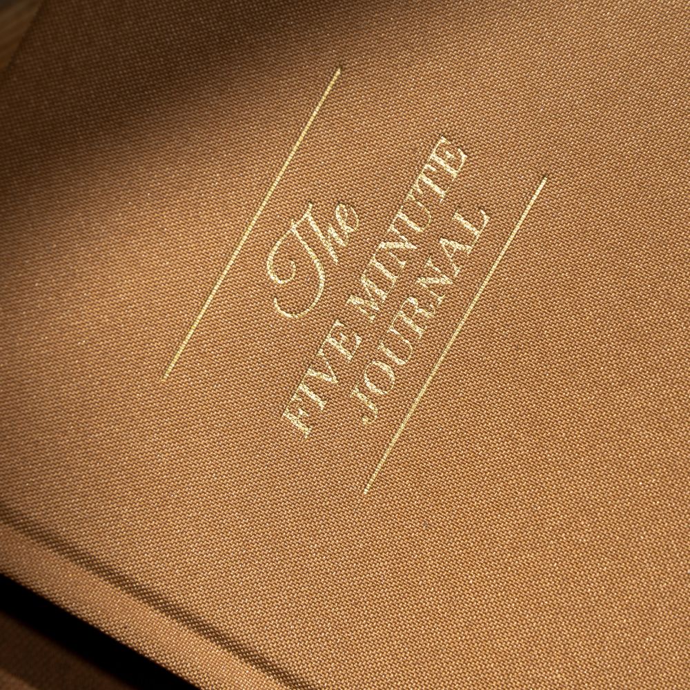 Brown journal with 'The Five Minute Journal' embossed on it