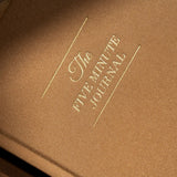 Brown journal with 'The Five Minute Journal' embossed on it