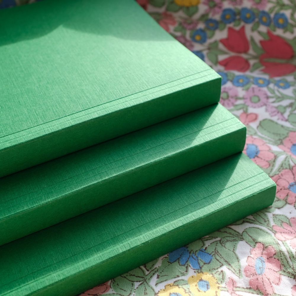 Stack of green foam mats on a floral-patterned surface