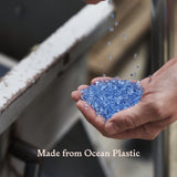Hand holding blue plastic flakes with 'Made from Ocean Plastic' text