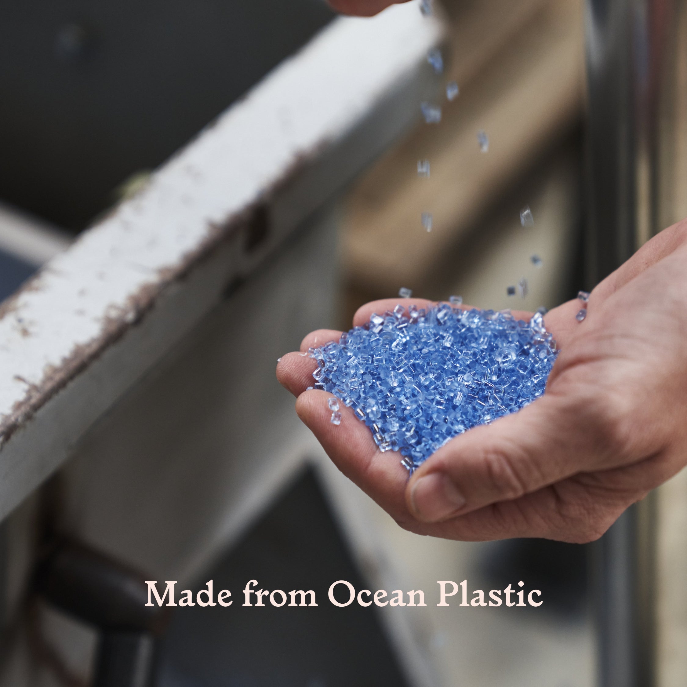 Hand holding blue plastic flakes with 'Made from Ocean Plastic' text
