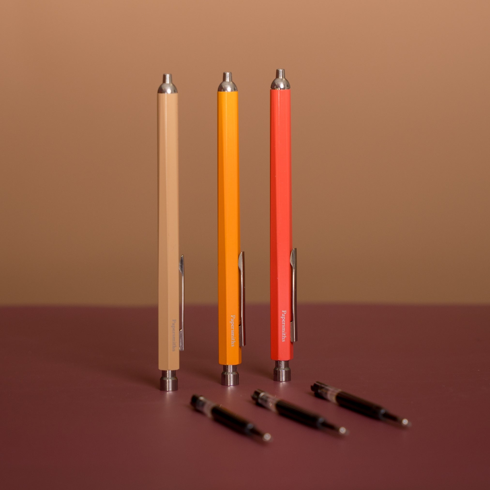 Set of colorful pens on a brown surface with a brown background