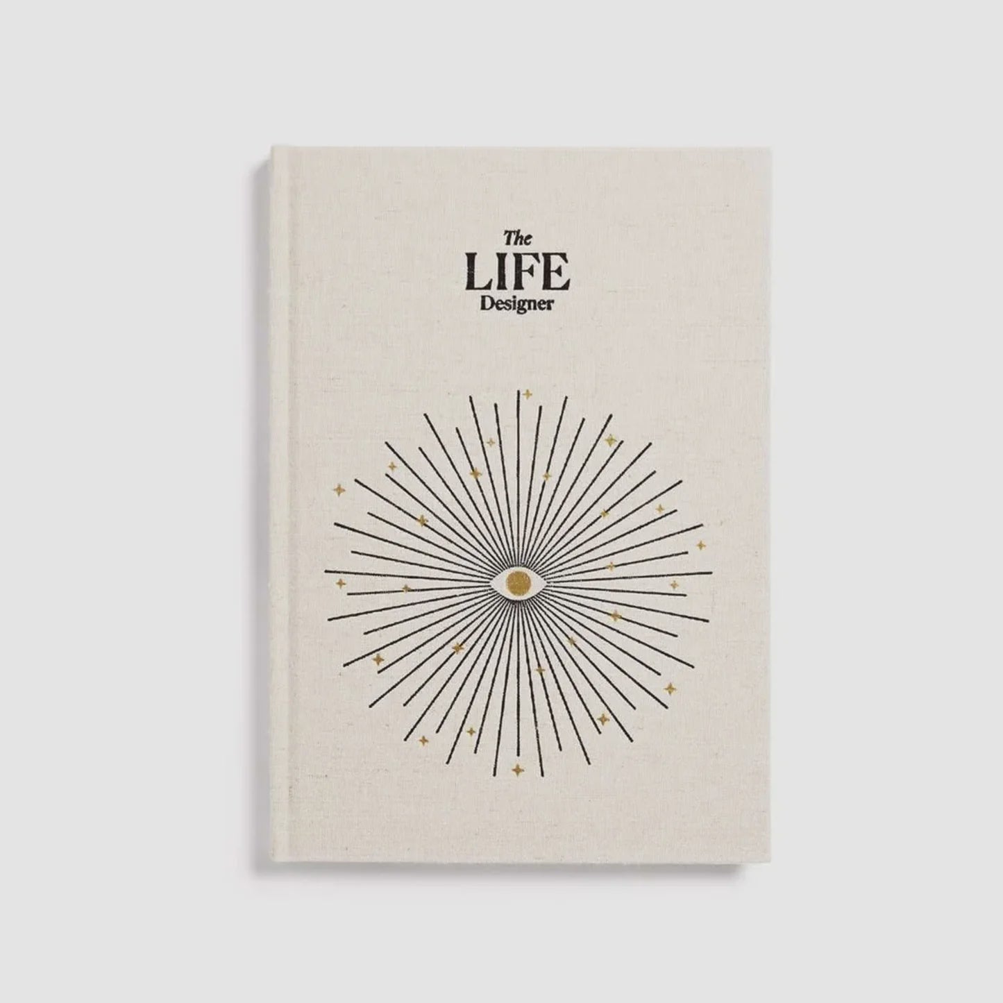 Beige book titled 'The LIFE Designer' with a starburst design on a light gray background