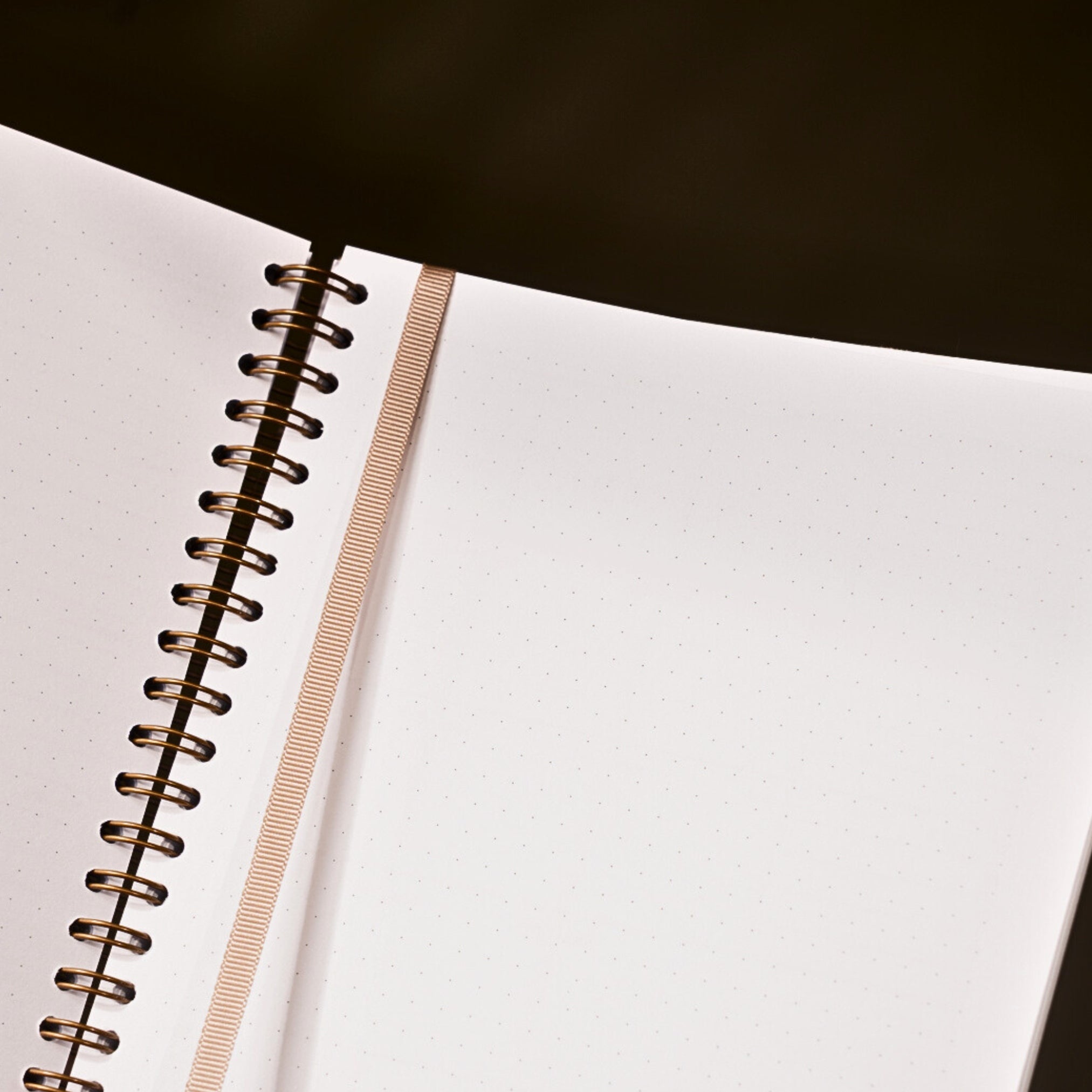 Open notebook with spiral binding on a dark surface
