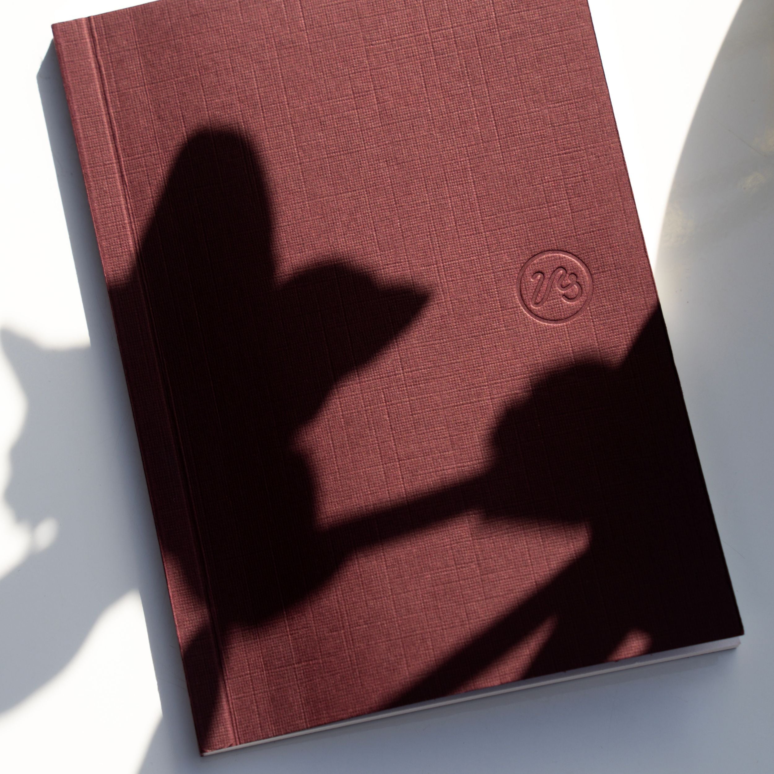 Burgundy pocket notebook with Papersmiths log on white background