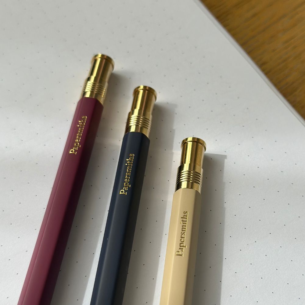 Three pens with gold accents on a white surface