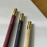 Three pens with gold accents on a white surface