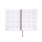 Open spiral-bound planner with calendar pages on a white background