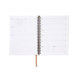 Spiral-bound planner with white pages on a white background