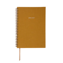 Yellow planner with spiral binding on a white background