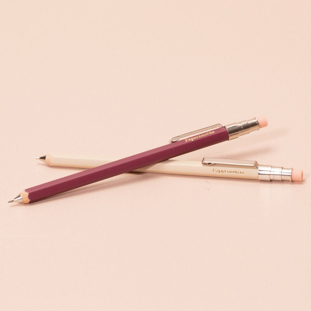 Two pocket-sized pencils with pink and beige accents on a beige background