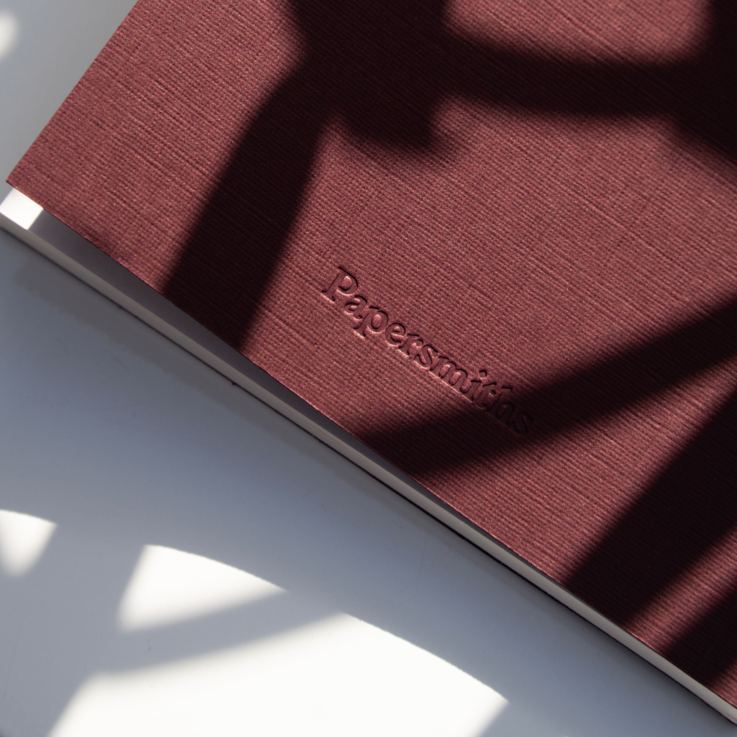 Burgundy pocket notebook with Papersmiths logo