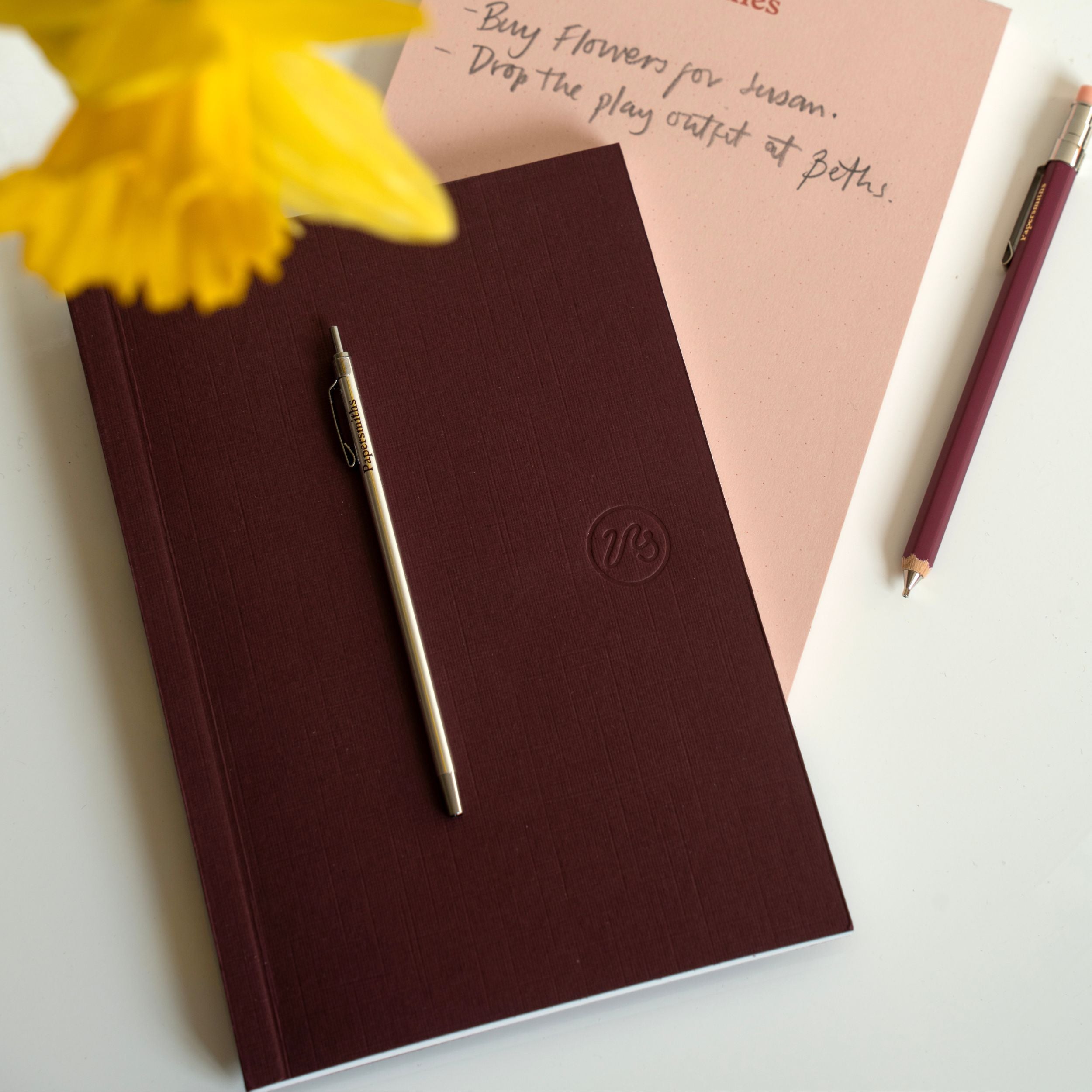 Burgundy pocket sized notebook with pocket sized pen and pencil