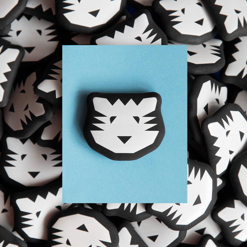 Black and white tiger head eraser on a blue card with more tiger head designs in the background.